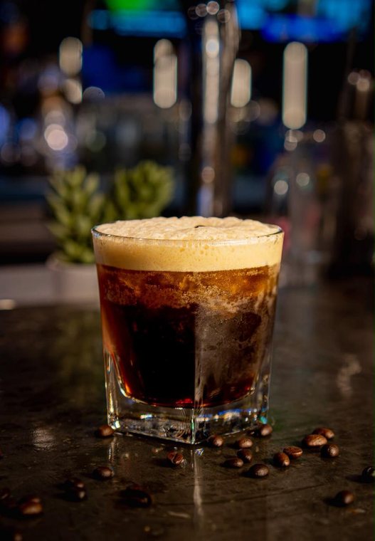 Carajillo Original servido en vaso corto con espuma y granos de café